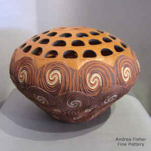 A textured spiral design on a seed pot with cutouts