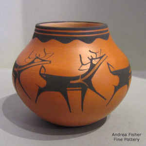 Deer, heart line and geometric design in black on a red jar