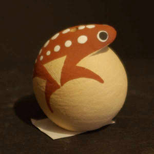 Frog on top of a buff-colored, egg-shaped seed pot