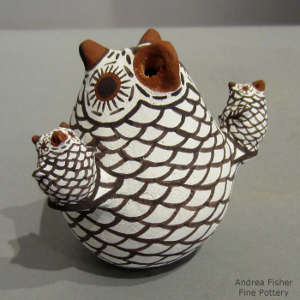 Two children on a polychrome owl storyteller